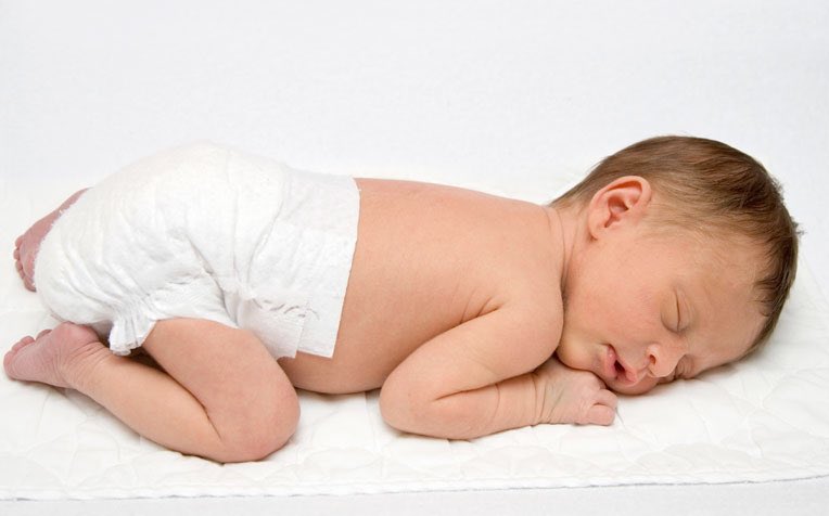Почему ребенок лежит на животе. Новорожденный на жмвот. Ребенок лежит на животе.