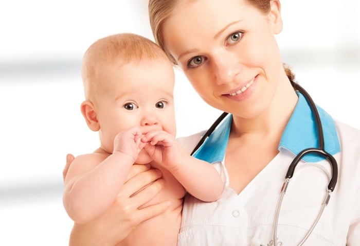 Девушка врач держит ребенка