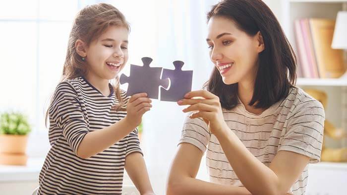 Mother and daughter playing with puzzle pieces